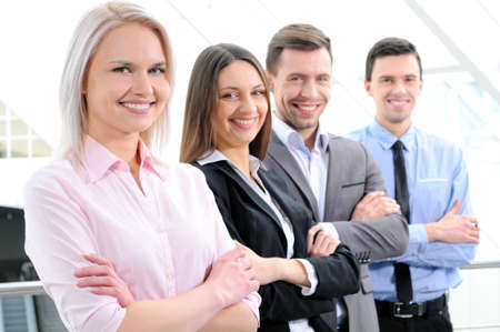 group of business people smiling in an office lined upの写真素材