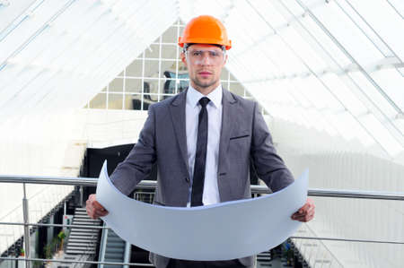 Young engineer with paper plansの写真素材