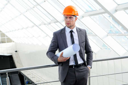 Young engineer with paper plansの写真素材