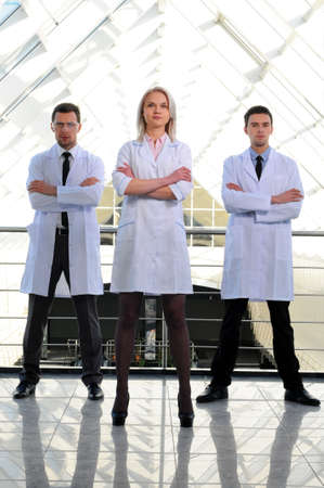 Portrait of a female doctor with two of her co-workers against modern hospital buildingの写真素材