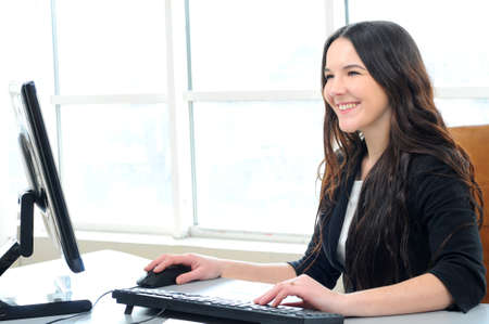 Portrait of a beautiful business woman working on her desk in an office environment の写真素材
