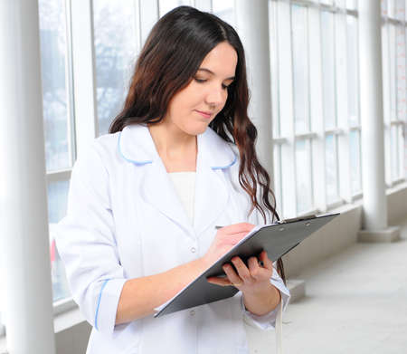 Portrait of a female doctor against modern hospital buildingの写真素材