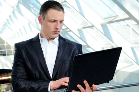 young businessman using laptop in business buildingの写真素材