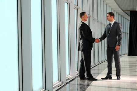Cheerful businesspeople, or businessman and client, handshakingの写真素材
