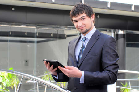 Man using electronic tablet in front of modern buildingの写真素材