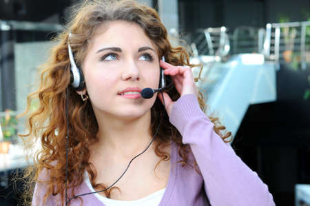 Portrait of happy smiling cheerful support phone operator in headset at officeの写真素材