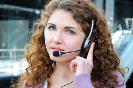 Portrait of happy smiling cheerful support phone operator in headset at officeの写真素材