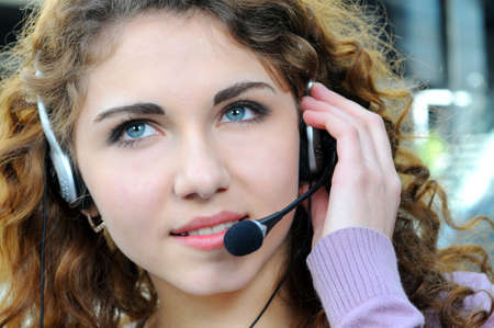 Portrait of happy smiling cheerful support phone operator in headset at officeの写真素材