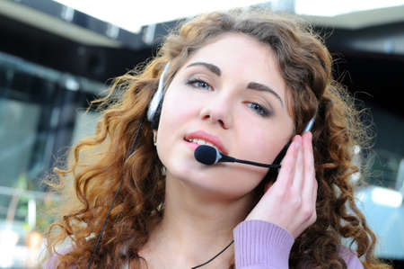 Portrait of happy smiling cheerful support phone operator in headset at officeの写真素材