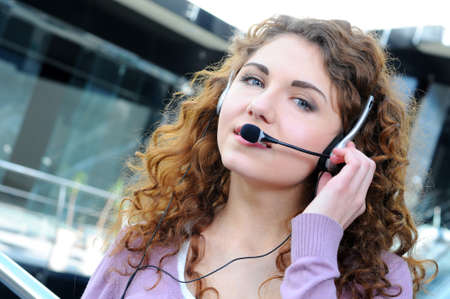 Portrait of happy smiling cheerful support phone operator in headset at officeの写真素材