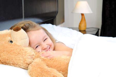 Portrait of cute girl lying in the bedの写真素材