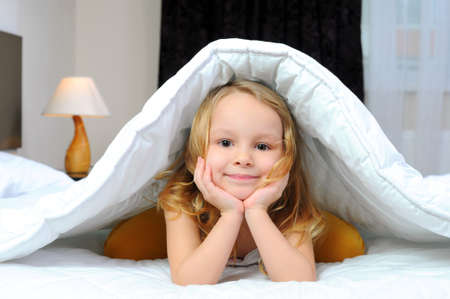 child with a blanket on the bed