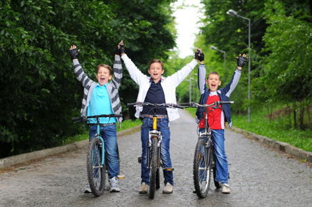 Portrait of three little cyclists riding their bikes