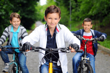 Portrait of three little cyclists riding their bikes