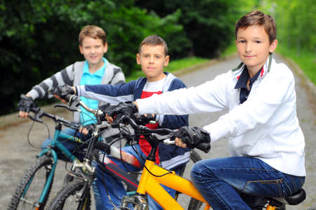 Portrait of three little cyclists riding their bikesの写真素材