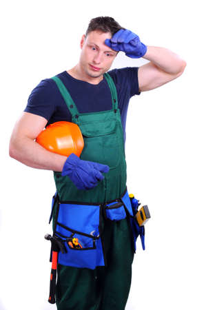 Tired man in a construction helmet on a white background の写真素材