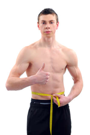 Men with perfect abs measuring his waistの写真素材