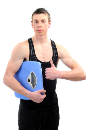 Muscular young man with weight scaleの写真素材