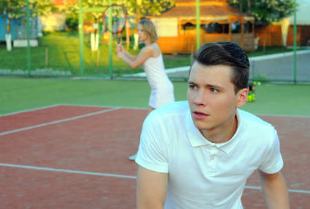 Couple playing doubles at the tennis courtの写真素材