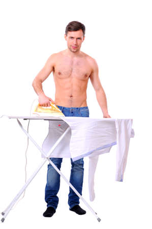 man ironing on a ironing board his shirt isolated on white backgroundの写真素材