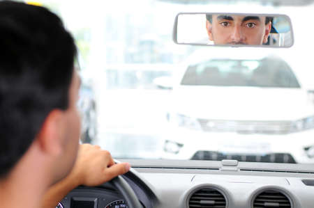 Young man looking car that wants to buy in the showroomの写真素材