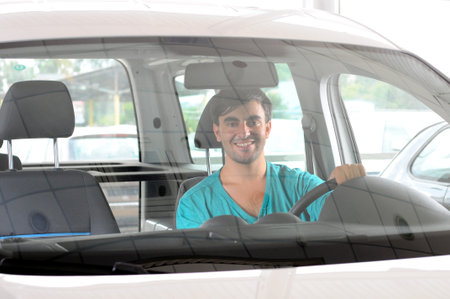 Young man looking car that wants to buy in the showroom