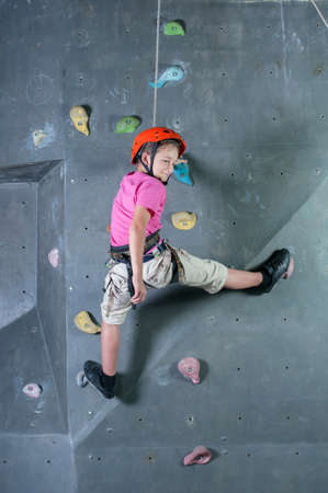 Child climbing on a wall in a climbing center.の写真素材