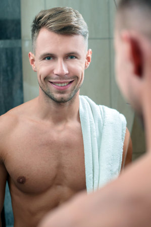 Attractive man drying his face in the mirrorの写真素材