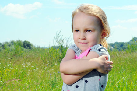 Cute little girl on the meadow in summer dayの写真素材