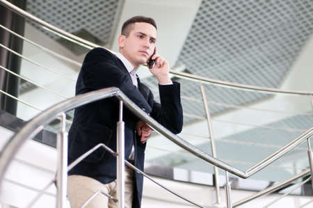 Portrait of a young smiling businessman in a business buildingの写真素材