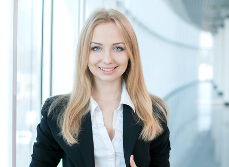 Portrait of a young beautiful business woman smiling at office buildingの写真素材