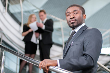 Smiling businessman with his colleagues in backgroundの写真素材