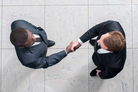 African businessman shaking hands with a caucasian one. view from aboveの写真素材