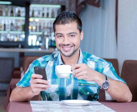 Images of India businessman in cafe and talking on the phone