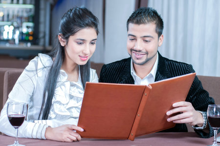 beautiful indian couple with wine glass. Having romantic talkの写真素材
