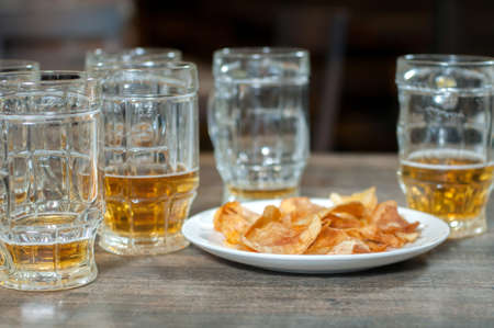 Beer mug and potato chips on a wooden tableの写真素材