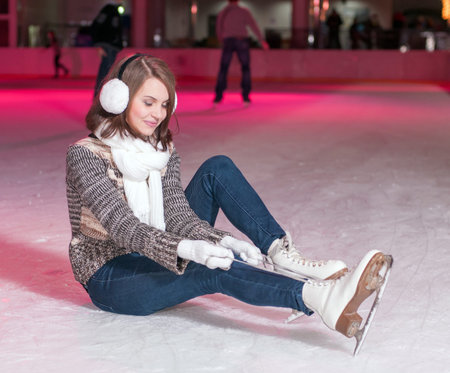 Young beautiful girl smiling on the ice skating indoors ice rink