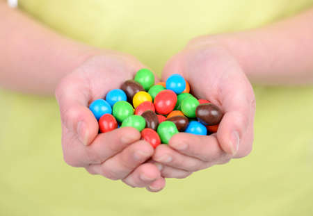 Portrait of beautiful girl with candy isolated on white backgroundの写真素材