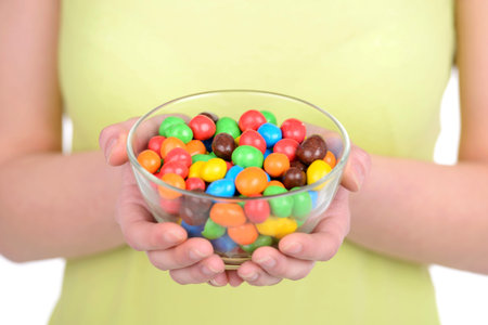 Portrait of beautiful girl with candy isolated on white backgroundの写真素材