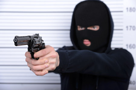 Busted burglar. Angry burglar threatens arms standing against police line-up