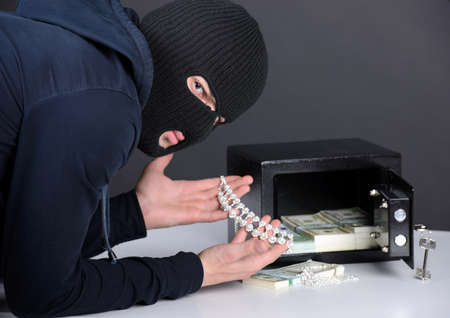 Thief burglar stealing money during home safe codebreakingの写真素材