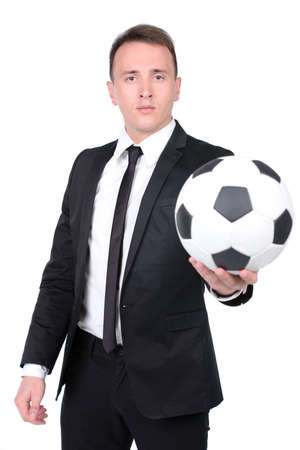 Full length portrait of a young handsome businessman kicking a football isolated on white backgroundの写真素材