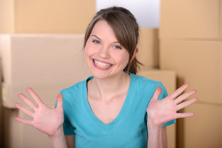 Young woman unpacking cardboard boxes after moving to new homeの写真素材