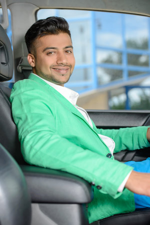 Portrait of young Indian business man, driving a car