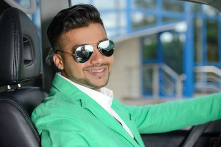 Portrait of young Indian business man, driving a carの写真素材