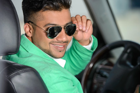Portrait of young Indian business man, driving a carの写真素材