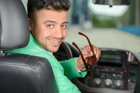 Portrait of young Indian business man, driving a carの写真素材