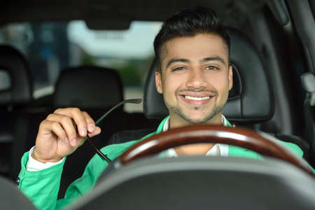 Portrait of young Indian business man, driving a carの写真素材