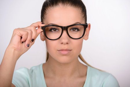 Portrait of smiling attractive young woman with glasses.