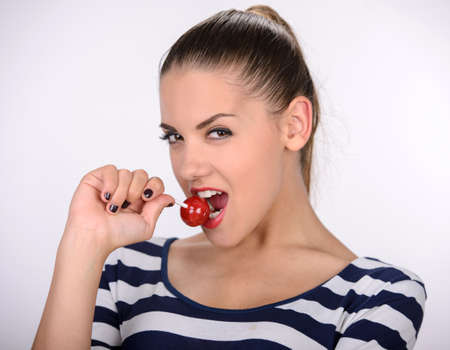 Beautiful young woman with lollipop on gray backgroundの写真素材